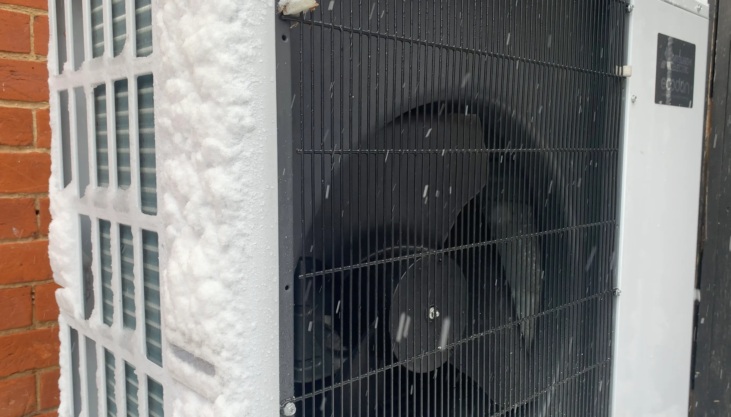 A heat pump outdoor unit with frost on its grille — the unit keeps drawing heat from outside air well below freezing.